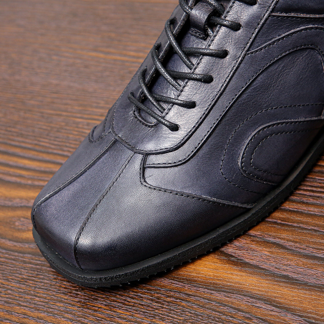 Men's dark gray leather sneaker close-up, lace eyelets and contrast stitching detail