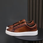 Men's brown leather low-top sneakers with lace-up closure and white sole