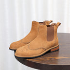 Brown suede pointed-toe Chelsea boots with elastic side gore and brogue-style perforations