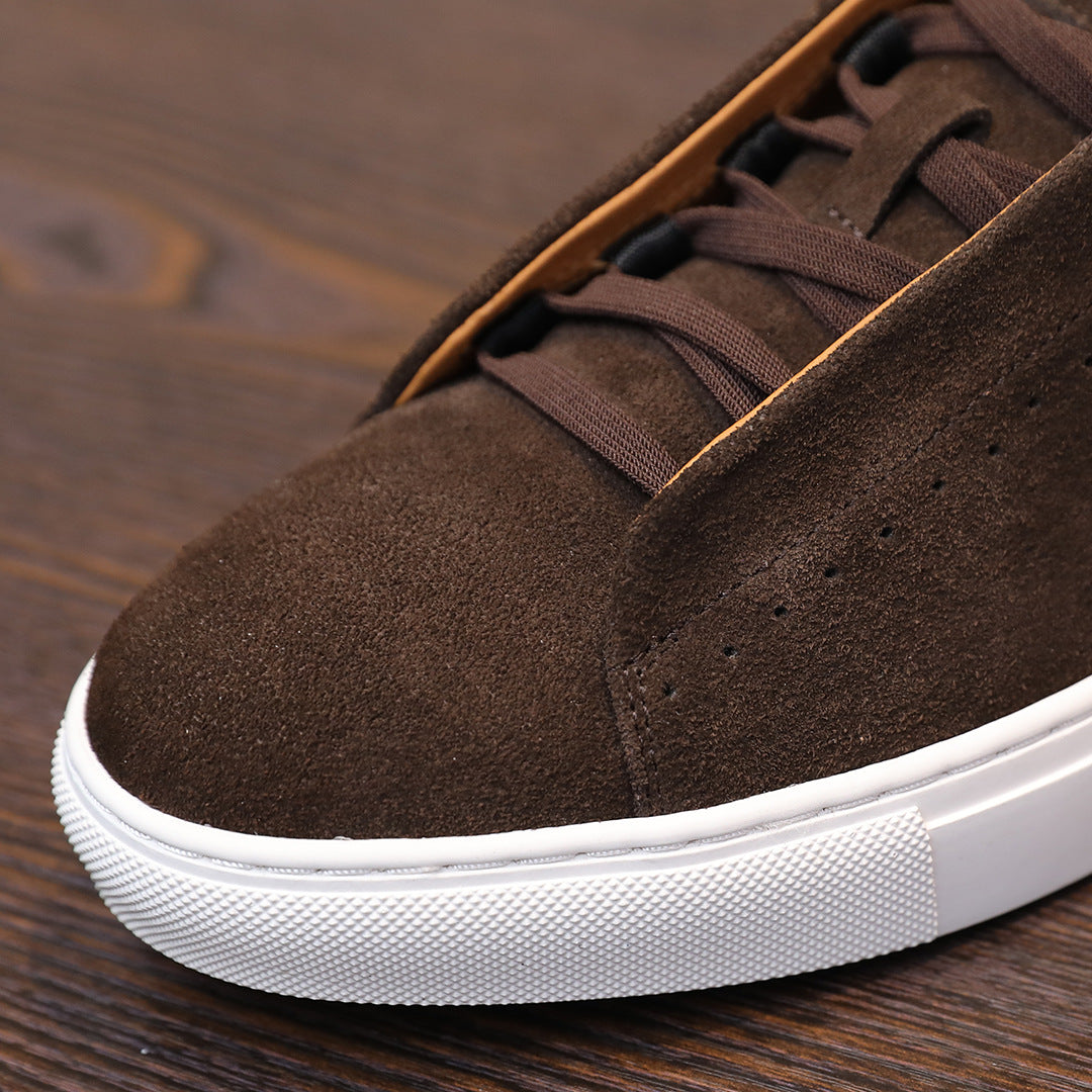Close-up of brown suede leather sneaker toe and laces with white rubber sole