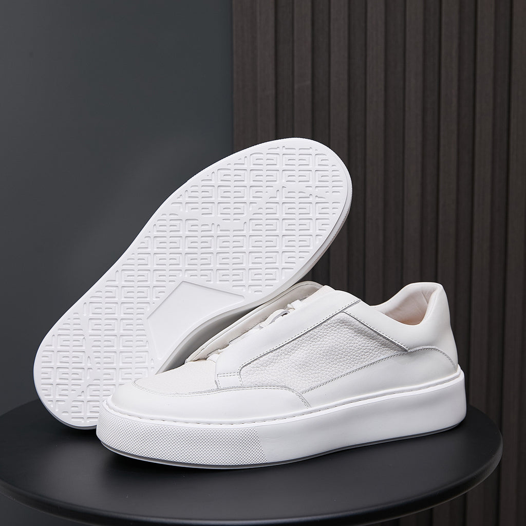 White genuine leather sneakers with visible tread outsole and minimalist side stitching