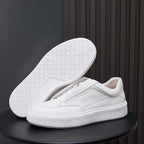 White genuine leather sneakers with visible tread outsole and minimalist side stitching