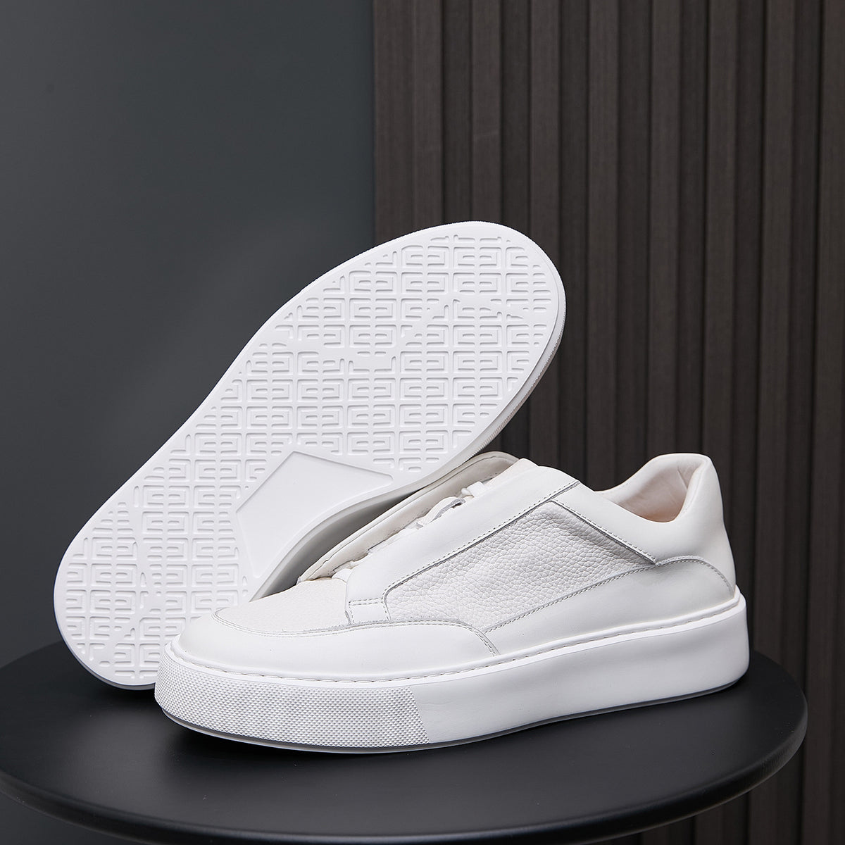 White genuine leather sneakers with visible tread outsole and minimalist side stitching