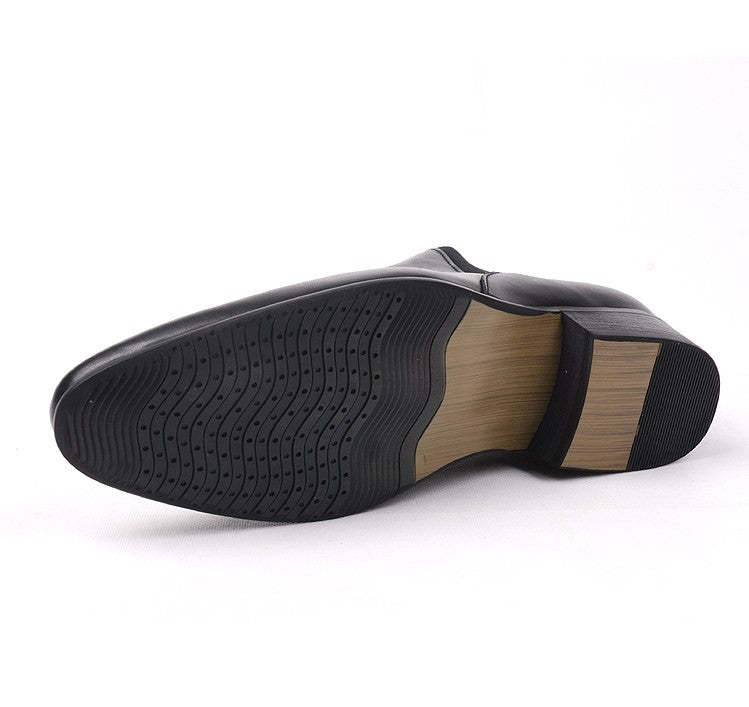 Bottom view of black Chelsea dress boots showing treaded rubber outsole