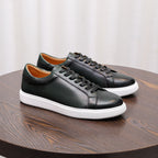 Men's dark leather sneakers with black laces and white rubber sole, angled side view