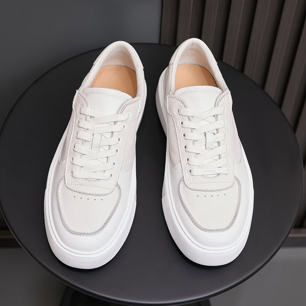 White genuine leather sneakers, front view with padded tongue and lace-up top