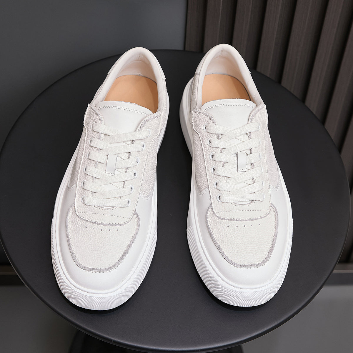 White genuine leather sneakers, front view with padded tongue and lace-up top