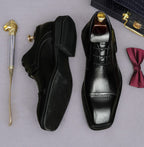 Men's black leather lace-up derby dress shoes, pointed toe with stitched panel detailing.