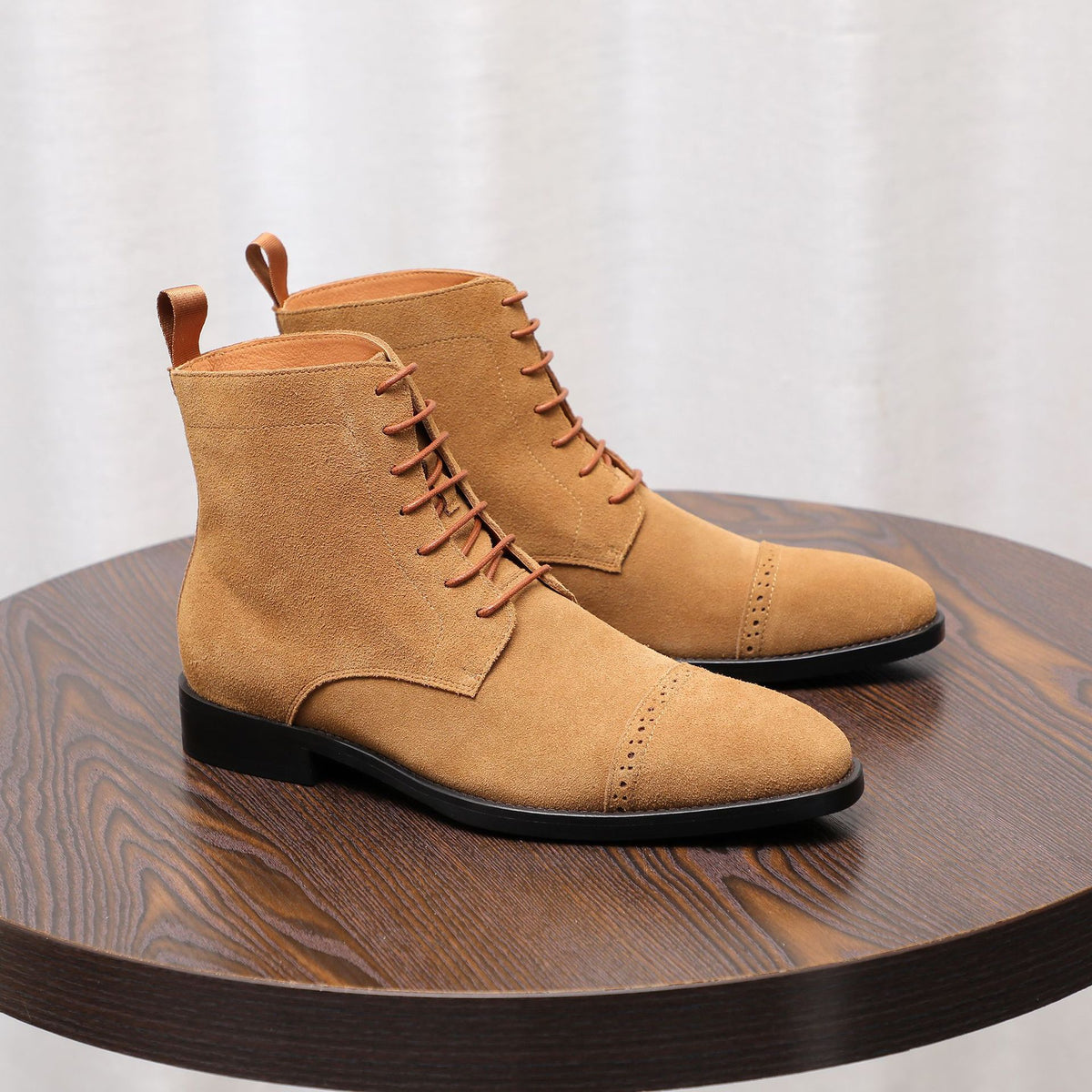 Men's tan suede chukka boots with plain toe, lace-up front, and black rubber sole