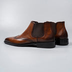 Brown leather Chelsea dress boots with elastic gore, perforated toe, and low block heel