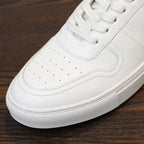 White leather sneaker close-up of lace eyelets and perforated toe
