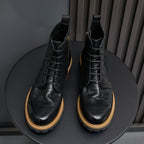 Pair of men's black leather ankle boots with pointed toe, lace-up, and side zip.