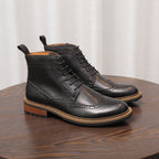 Black leather lace-up chukka boots with perforated toe and thick sole