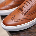 Close-up of men's brown leather sneaker toe with laces and white textured sole
