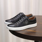Pair of black leather lace-up sneakers with textured finish and white sole