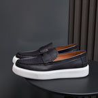 Black leather slip-on sneakers with strap detail and thick white rubber sole