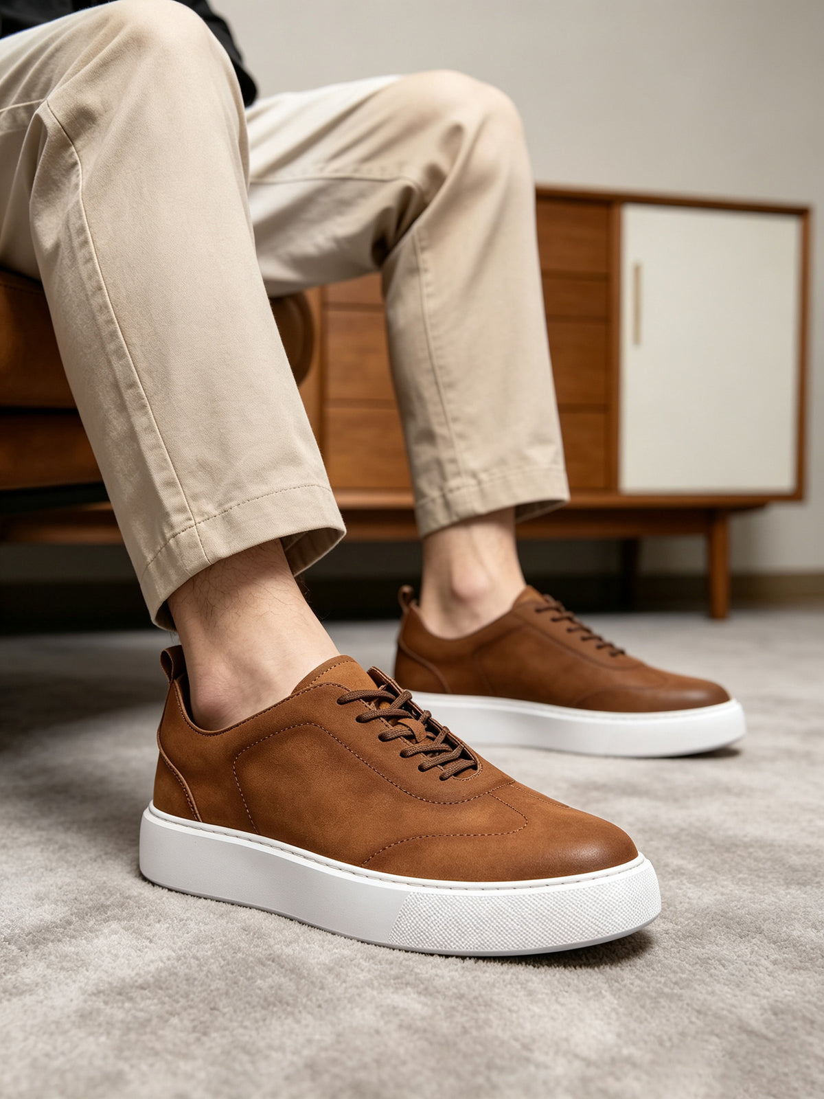 Brown leather sneakers with lace-up front and white sole, casual low top
