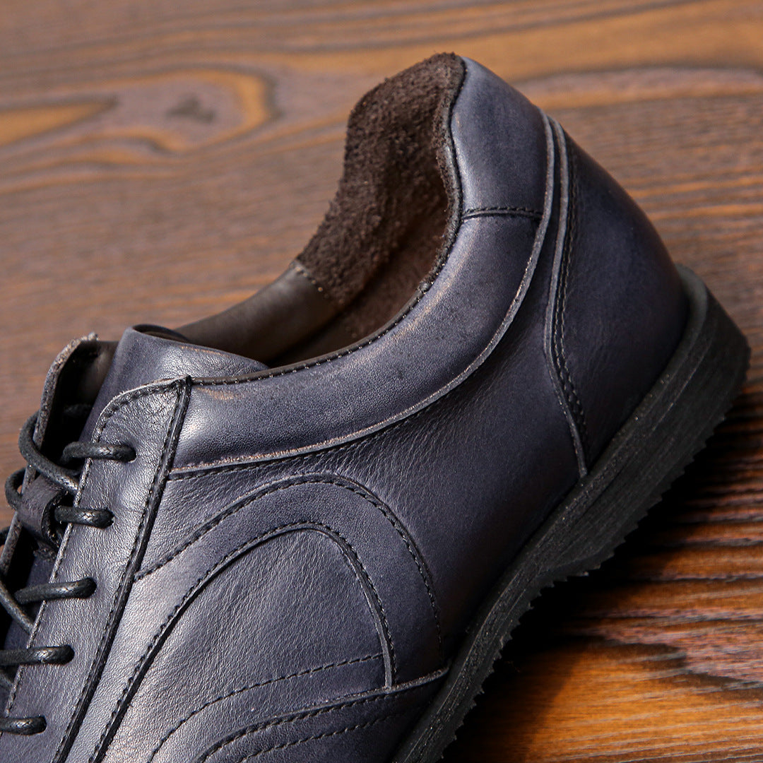 Men's dark gray leather sneaker close-up, padded collar and lace-up side profile