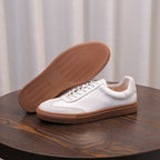 White leather sneaker outsole view with tan rubber tread