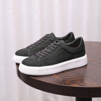 Charcoal gray leather low-top sneakers with lace-up front and white sole