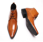 Cognac tan leather lace-up dress boots with pointed toe and low heel.