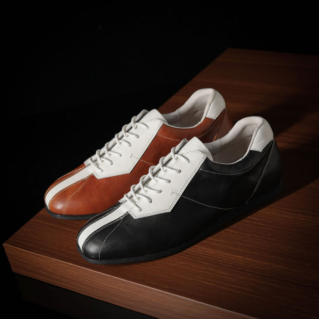 Two-tone leather sneakers: brown/white pair and black/white pair, lace-up low-top.