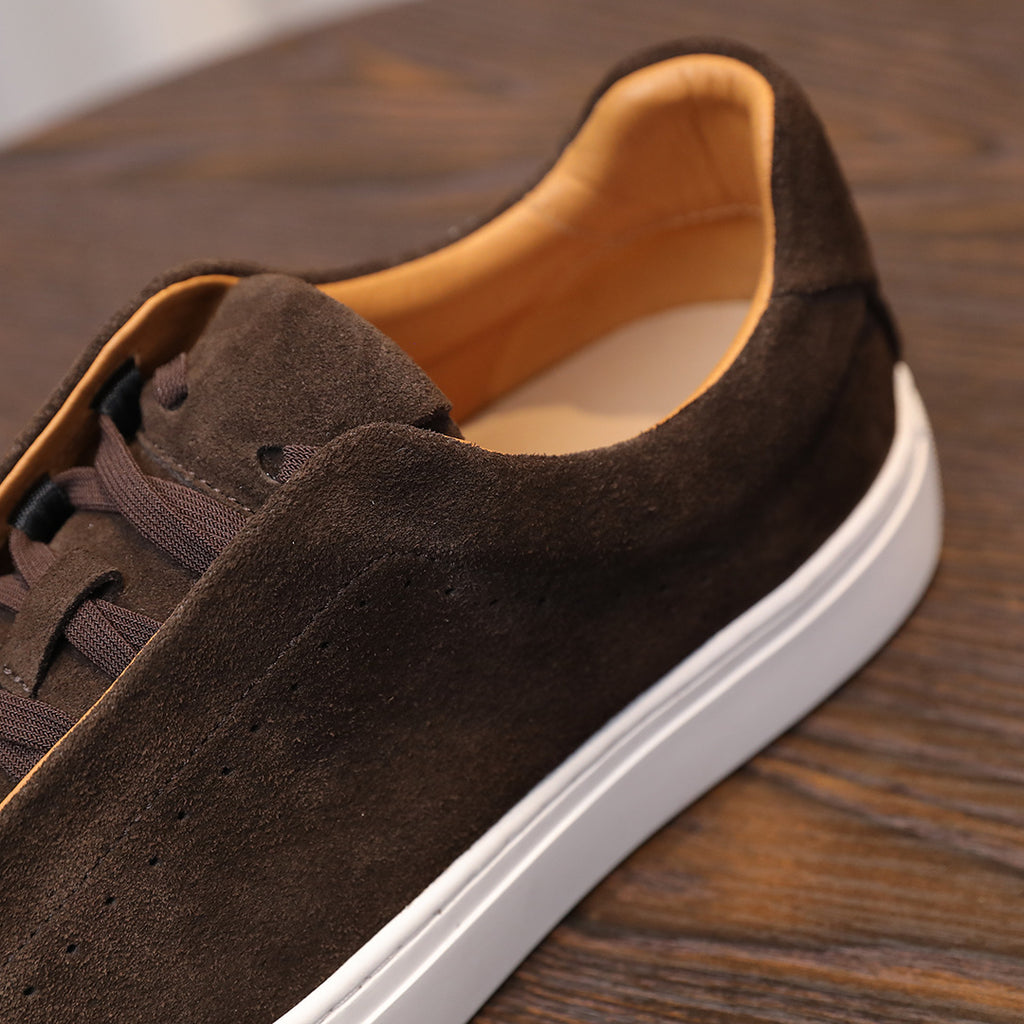 Side close-up of brown suede lace-up sneaker with tan lining and white edge sole