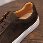Side close-up of brown suede lace-up sneaker with tan lining and white edge sole