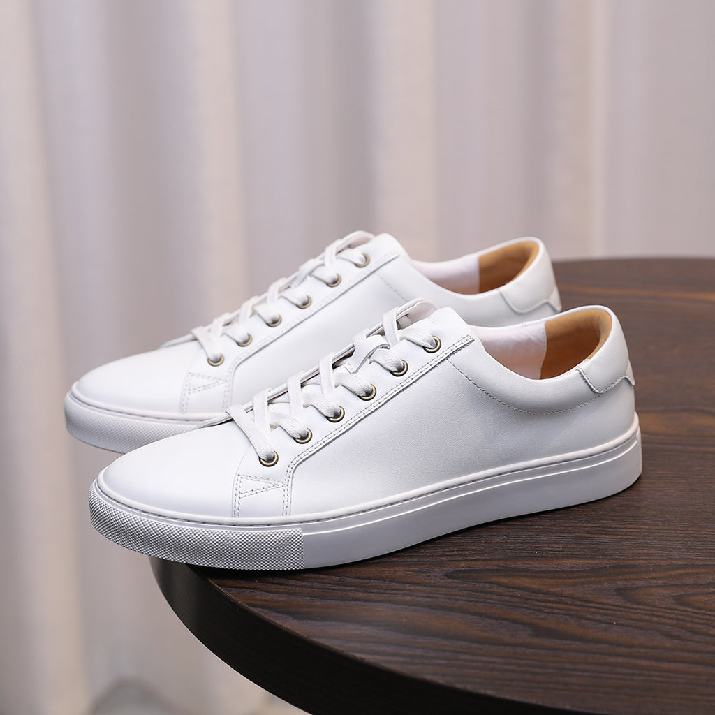 Men's white leather low-top sneakers with lace-up front and padded collar