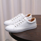 Men's white leather low-top sneakers with lace-up front and padded collar