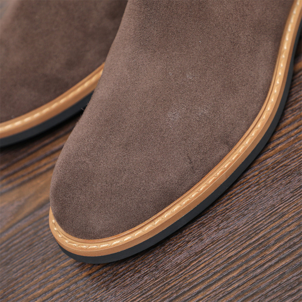 Close-up of men's suede chelsea dress boot toe with tan welt and textured outsole