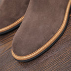 Close-up of men's suede chelsea dress boot toe with tan welt and textured outsole