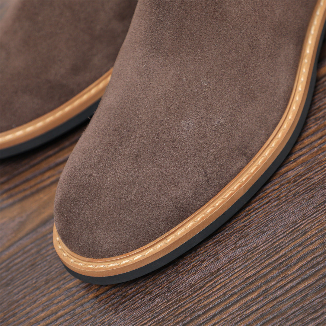 Close-up of men's suede chelsea dress boot toe with tan welt and textured outsole
