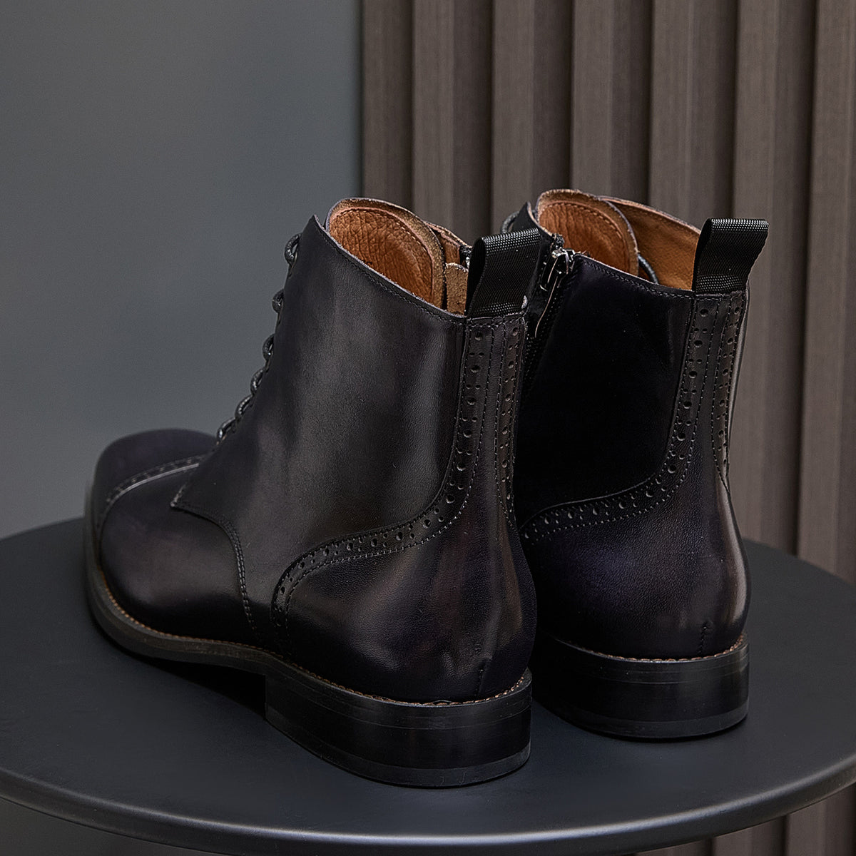 Men's dark leather side pull dress boots pair with stitched heel counter