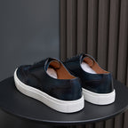 Dark blue leather sneakers from heel view with white rubber sole