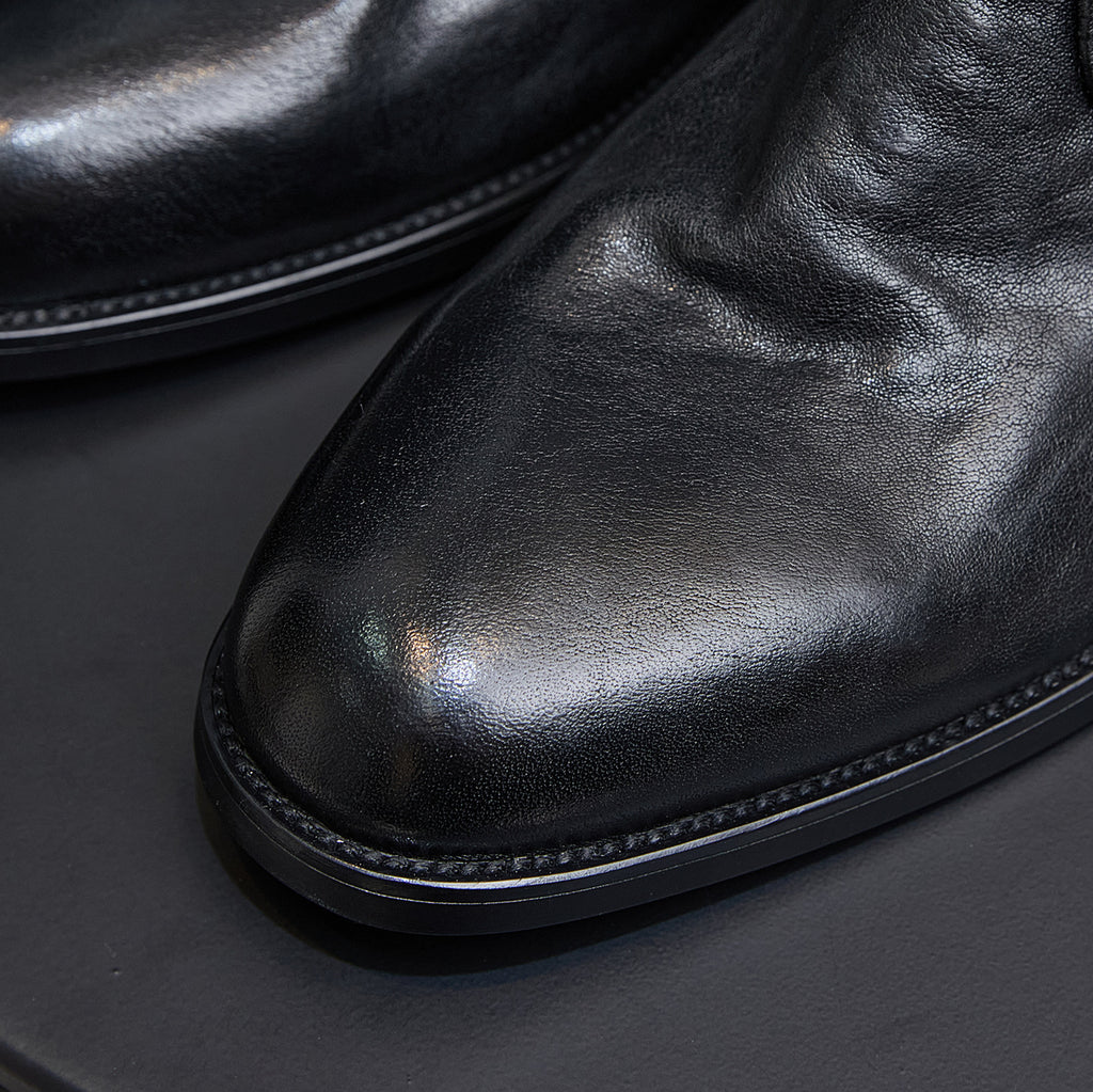 Black leather chukka boot toe and sole, close-up of stitching and outsole.