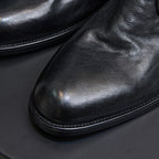 Black leather chukka boot toe and sole, close-up of stitching and outsole.