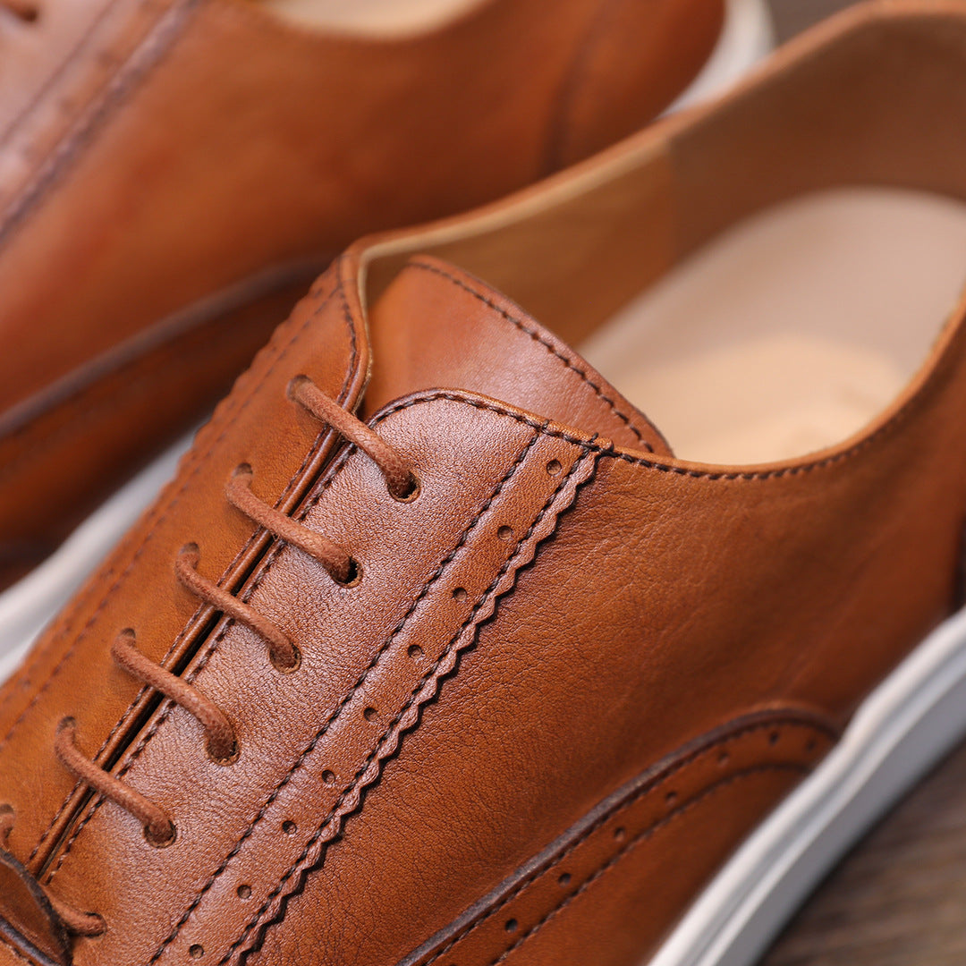 Close-up of men's brown leather lace-up sneakers with stitching detail and white sole