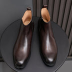 Pointed-toe leather side-zip dress boots in dark brown, pair on round stand