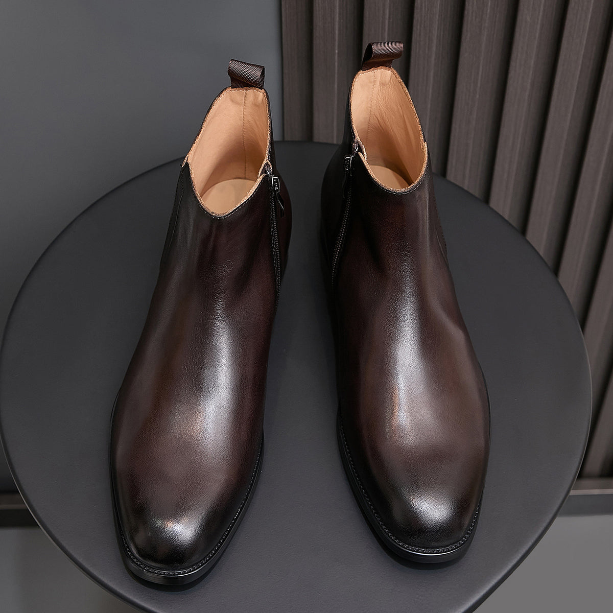 Pointed-toe leather side-zip dress boots in dark brown, pair on round stand