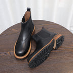 Black Chelsea boots with pointed toe and elastic gore, with outsole tread visible