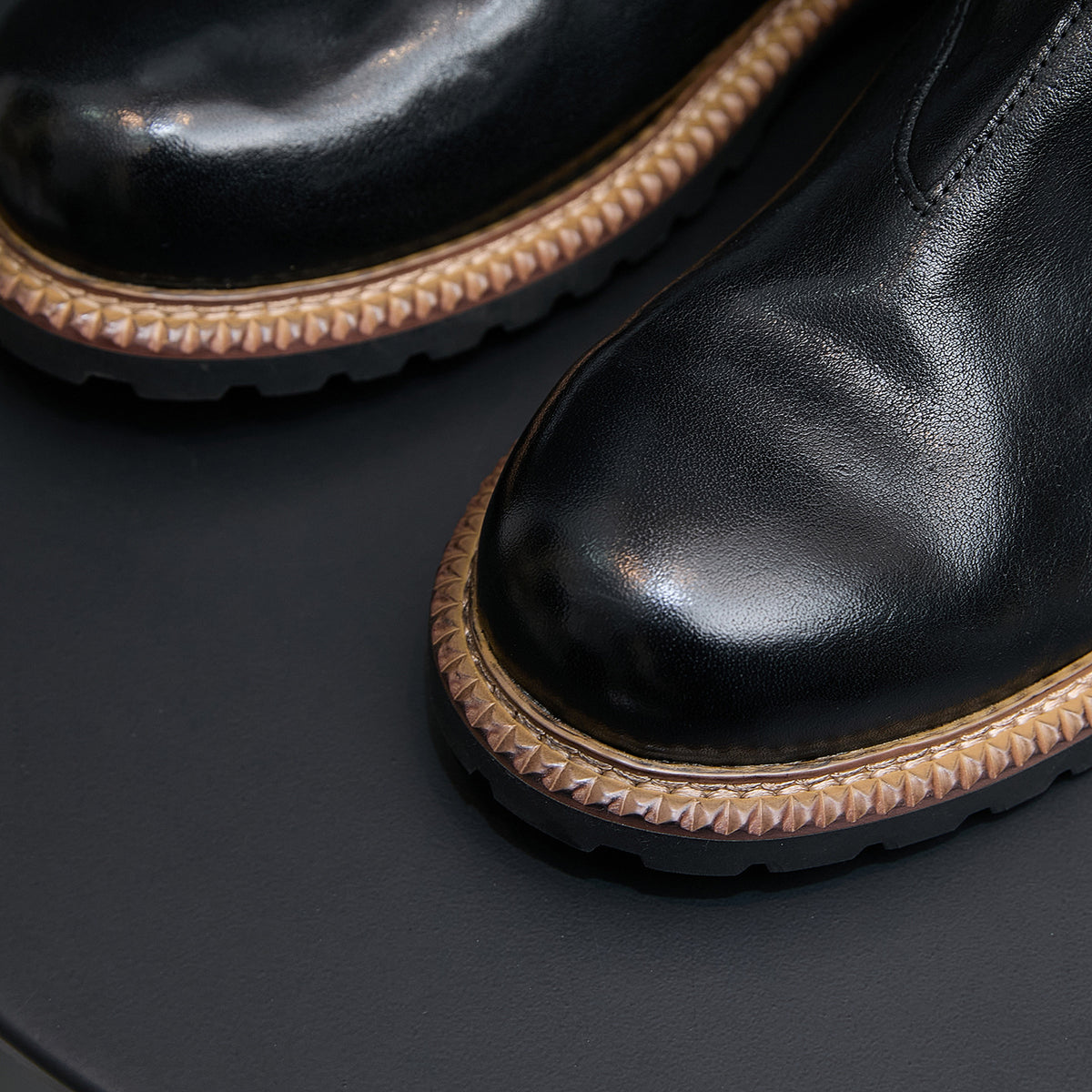 Men's pointed-toe suede Chelsea dress boots, black, close-up of toe and textured sole edge