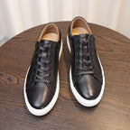 Black leather sneakers with lace-up closure and white rubber outsole