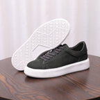 Charcoal gray leather sneakers with textured sole visible, lace-up style