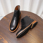 Black leather lace-up ankle boots with orange welt and textured rubber sole