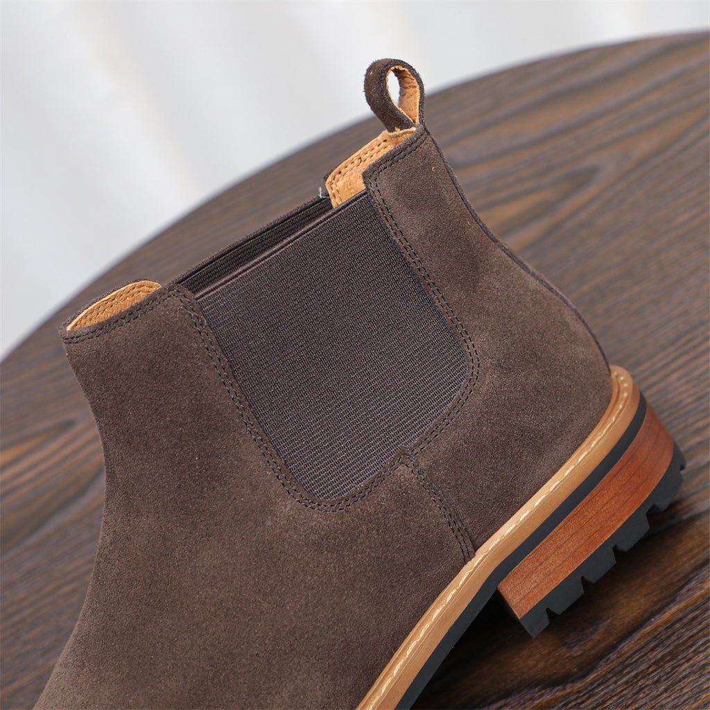 Dark brown suede pointed-toe Chelsea boot with elastic side panels and rubber sole.