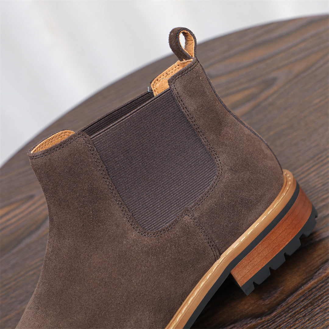 Dark brown suede pointed-toe Chelsea boot with elastic side panels and rubber sole.