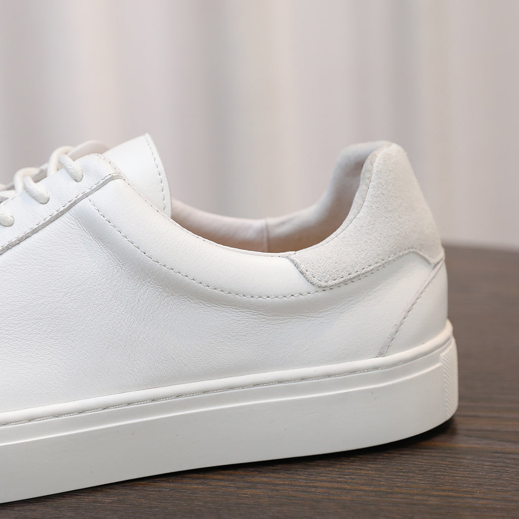 White leather sneaker side view with padded collar and smooth upper finish