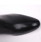 Close-up of black leather boot toe with smooth finish and stitched seam.