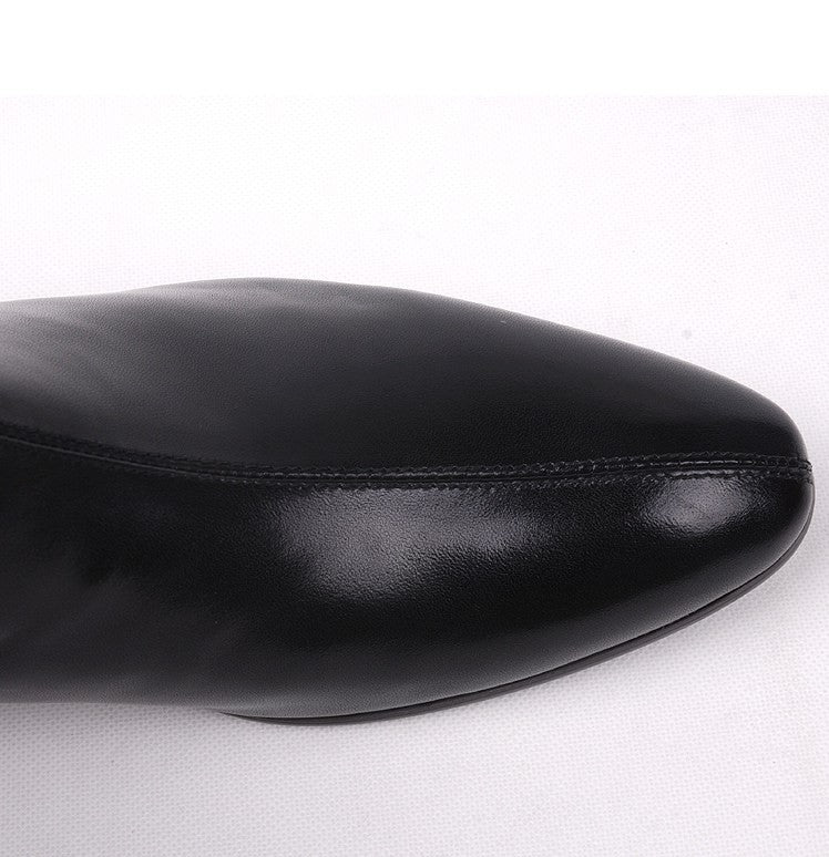 Close-up of black leather boot toe with smooth finish and stitched seam.